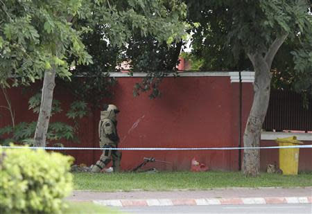 A Cambodian Mine Action Center (CMAC) officer prepares to detonate a bomb that security officials discovered outside of Cambodia's National Assembly in central Phnom Penh, September 13, 2013. REUTERS/Samrang Pring