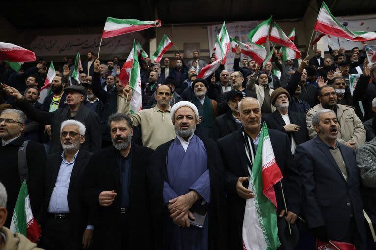 Hamid Rasaee (centro), un clérigo musulmán chiíta iraní y exmiembro de la Asamblea Consultiva Islámica, asiste a un mitin de campaña electoral en un estadio deportivo (Photo by ATTA KENARE / AFP)