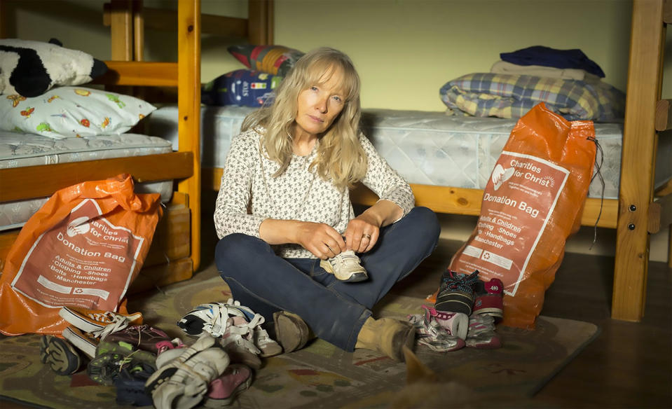 Still from "The Leftovers" of a lady sitting with donation bags surrounding her