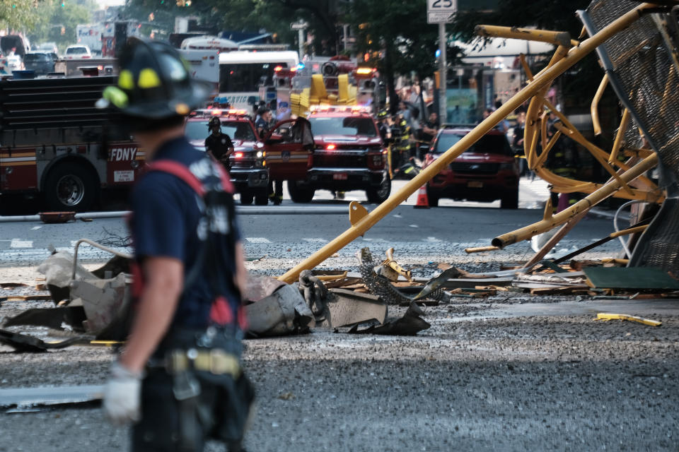 Debris from a crane collapse sits in the road as emergency personnel gather at the scene in Manhattan on Wednesday. 