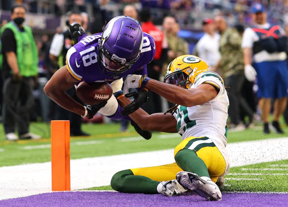 Justin Jefferson #18 of the Minnesota Vikings dives into the end zone for a touchdown as Eric Stokes #21 of the Green Bay Packers tries to tackle in the fourth quarter at U.S. Bank Stadium on November 21, 2021 in Minneapolis, Minnesota.