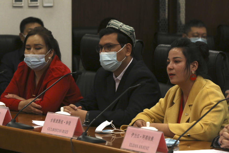 Gulbostan Rozi, right, a representative of ethnic minority women in Kashgar in western China's Xinjiang Uyghur Autonomous Region, speaks as two other Uyghur residents of Xinjiang listen during a press conference at the Ministry of Foreign Affairs in Beijing, Thursday, March 18, 2021. China on Thursday accused Adrian Zenz, a scholar and outspoken critic of its policies toward Muslim minorities, of fabricating charges that have helped bring sanctions against Chinese officials and companies operating in the Xinjiang region. (AP Photo/Sam McNeil)