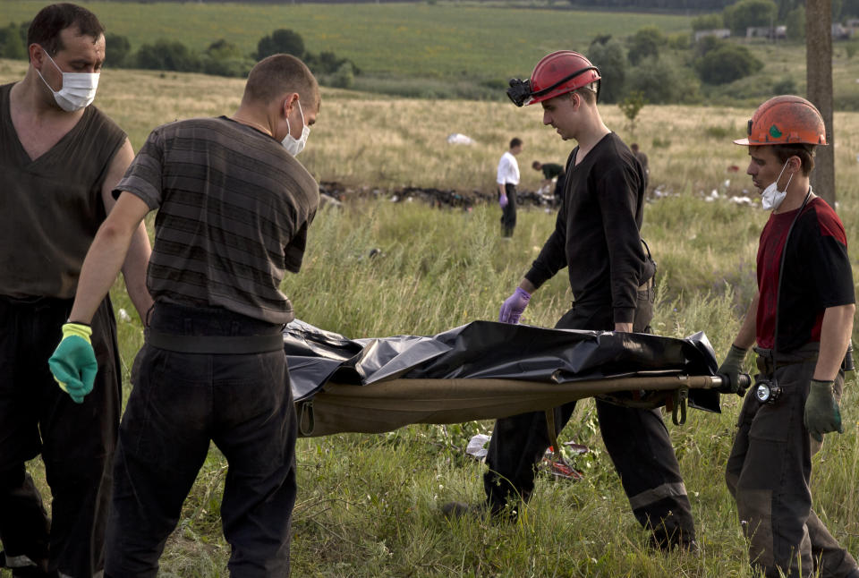 FILE - Ukrainian miners carry the body of a victim at the crash site of Malaysia Airlines Flight 17 near the village of Hrabove, eastern Ukraine, on July 19, 2014. A Dutch court on Thursday is set to deliver verdicts in the long-running trial of three Russians and a Ukrainian rebel for their alleged roles in the shooting down of Malaysia Airlines flight MH17 over conflict-torn eastern Ukraine. (AP Photo/Vadim Ghirda, File)