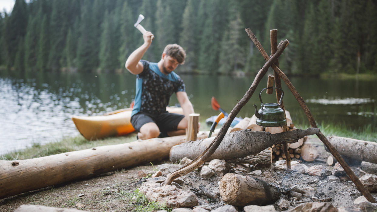  Do you need a camping axe?: A man chops wood for a campfire. 