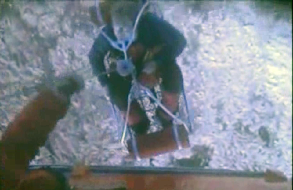 This framegrab image provided by the U.S. Coast Guard shows one of three crew members from the yacht Low Speed Chase being rescued from the Farallon Islands west of San Francisco Saturday April 14, 2012 by the U.S. Coast Guard. The sail boat carrying eight crew members ran aground during a race off San Francisco Saturday, killing one person and leaving four others missing, the Coast Guard said. (AP Photo/US Coast Guard)