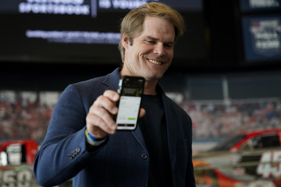 Fox Sports broadcaster Greg Olsen, who placed the first ceremonial bet in North Carolina, shows his receipt during a DraftKings event celebrating the launch of mobile and online sports wagering across the state at the NASCAR Hall of Fame, Monday, March 11, 2024, in Charlotte, N.C. (AP Photo/Erik Verduzco)