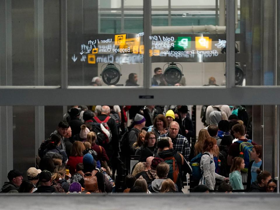 Travelers wait in line to go through security in Terminal 1 at Minneapolis St. Paul Airport, Wednesday, Dec. 21, 2022, in Minneapolis.