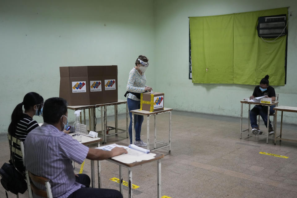 A woman votes during an election re-run to decide the governor in Barinas, Venezuela, Sunday, Jan. 9, 2022. Voters in the home state of the late Venezuelan President Hugo Chávez are voting again Sunday in a special gubernatorial election called after the opposition contender in November’s regular contest was retroactively disqualified as he was ahead in the vote count. (AP Photo/Matias Delacroix)