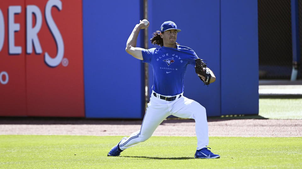 Toronto Blue Jays pitcher Kevin Gausman throws long toss in the outfield before a spring training baseball game against the Detroit Tigers at TD Ballpark, in Dunedin, Fla., Friday, March 25, 2022. (Steve Nesius/The Canadian Press via AP)