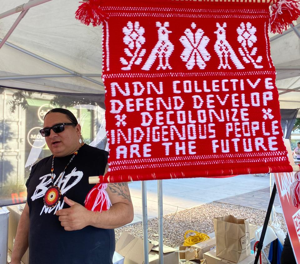 Activist Nick Tilsen, president and CEO of NDN Collective, answers questions at the group's booth during the Indigenous People’s Day Phoenix Fest.