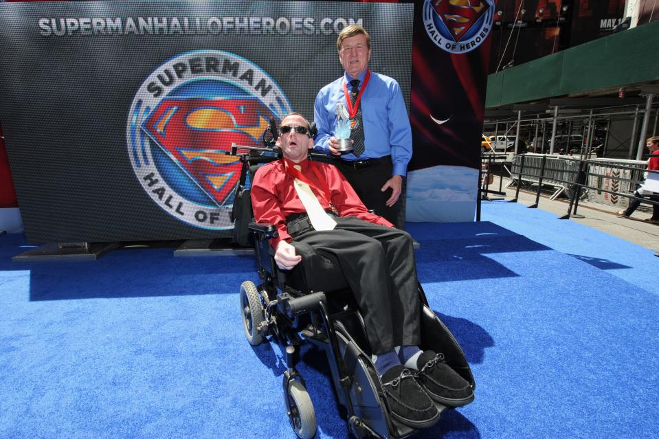 NEW YORK, NY - MAY 13: Marathon legends Rick Hoyt (L) and Dick Hoyt pose with the Superman Hall of Heroes award at the Superman Hall Of Heroes inaugural event at Times Square on May 13, 2014 in New York City.  (Photo by Ilya S. Savenok/Getty Images for WBCP)