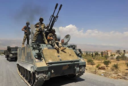 Lebanese army soldiers on armoured carriers and military vehilces advance towards the Sunni Muslim border town of Arsal, in eastern Bekaa Valley as part of reinforcements August 5, 2014. REUTERS/Hassan Abdallah