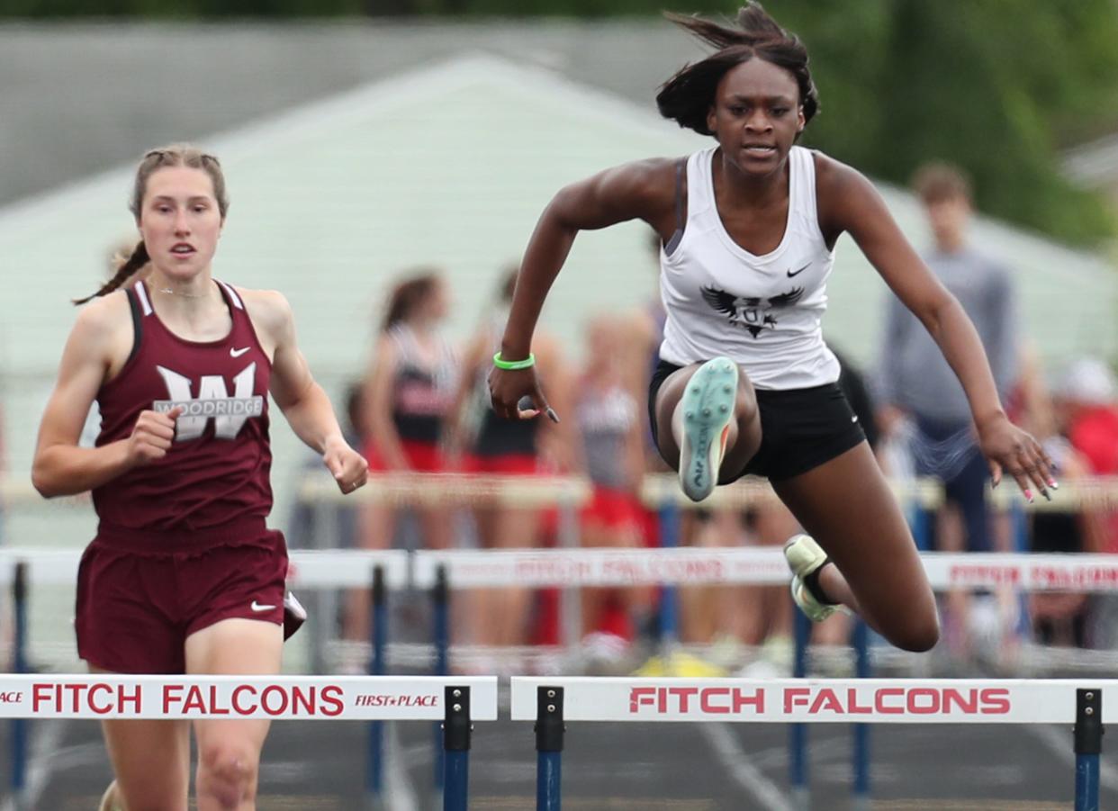 Buchtel's DaMya Barker clears the hurdle on her way to first place as Woodridge's Anna Rorrer follows for second place in the girls 300 meter hurdles at the Div. II regional track and field tournament at Austintown Fitch High School on Saturday.