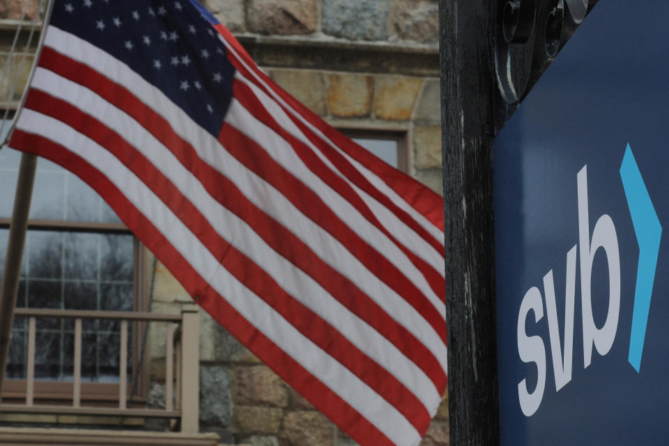 A U.S. flag flies outside a branch of the Silicon Valley Bank in Wellesley, Massachusetts, U.S., March 13, 2023.     REUTERS/Brian Snyder