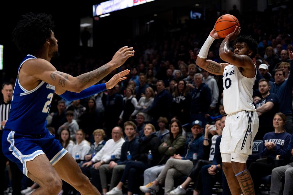 Xavier Musketeers guard Dayvion McKnight (20) hits a 3-point basket as Seton Hall Pirates guard Isaiah Coleman (21) guards him in the second half of the basketball game between Xavier Musketeers and Seton Hall Pirates at the Cintas Center in Cincinnati on Saturday, Dec. 23, 2023.