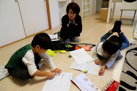 Motoko Hagiwara looks at her children doing their homework in the living room of their house at Higashinohara district in Inzai, Chiba Prefecture, Japan, November 6, 2018. REUTERS/Kim Kyung-Hoon