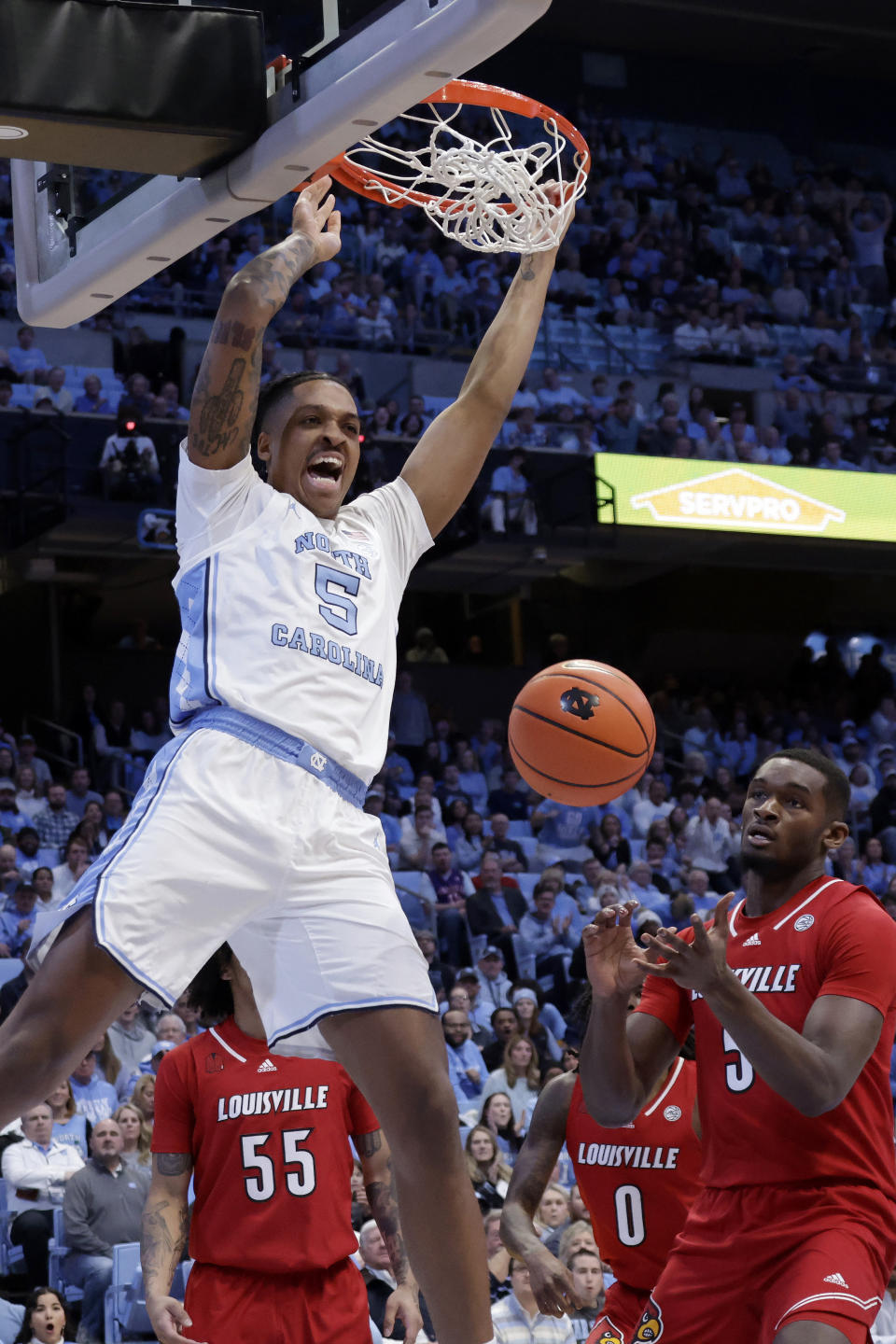 North Carolina forward Armando Bacot (5) dunks against Louisville guards Skyy Clark (55) and Mike James (0) and forward Brandon Huntley-Hatfield during the first half of an NCAA college basketball game Wednesday, Jan. 17, 2024, in Chapel Hill, N.C. (AP Photo/Chris Seward)