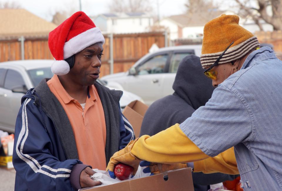 Resharde Law collects food for his family at a Food Bank of the Rockies distribution in Denver, Colorado, on Dec. 19. Law, who works as a mover, wore a Santa hat in an effort to spread cheer during the distribution.