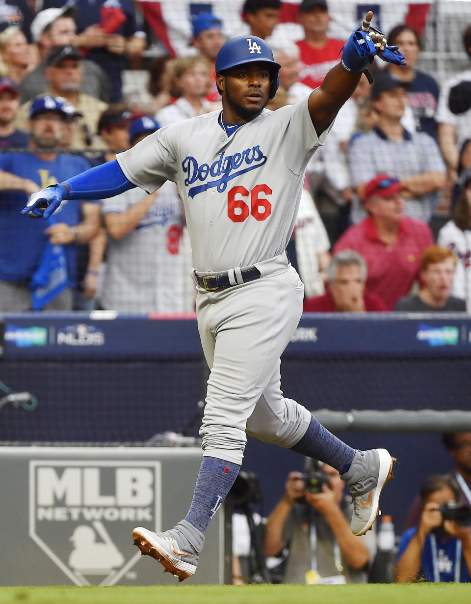 Los Angeles Dodgers' Yasiel Puig (66) celebrates a two-run single hit by Los Angeles Dodgers' David Freese against the Atlanta Braves during the sixth inning in Game 4of baseball's National League Division Series, Monday, Oct. 8, 2018, in Atlanta. (AP Photo/John Amis)