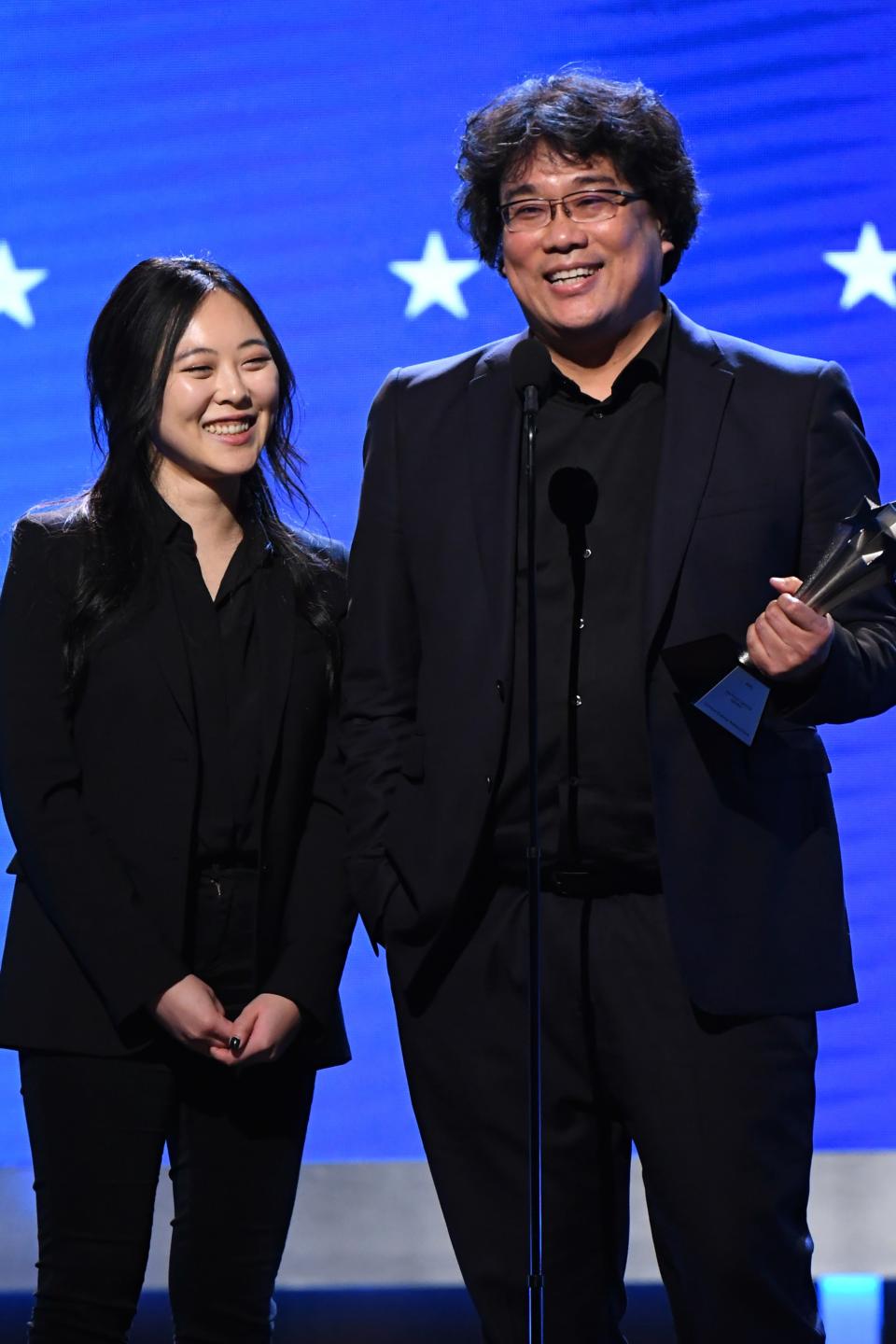 Bong Joon-ho accepting an award with Sharon Choi translating for him