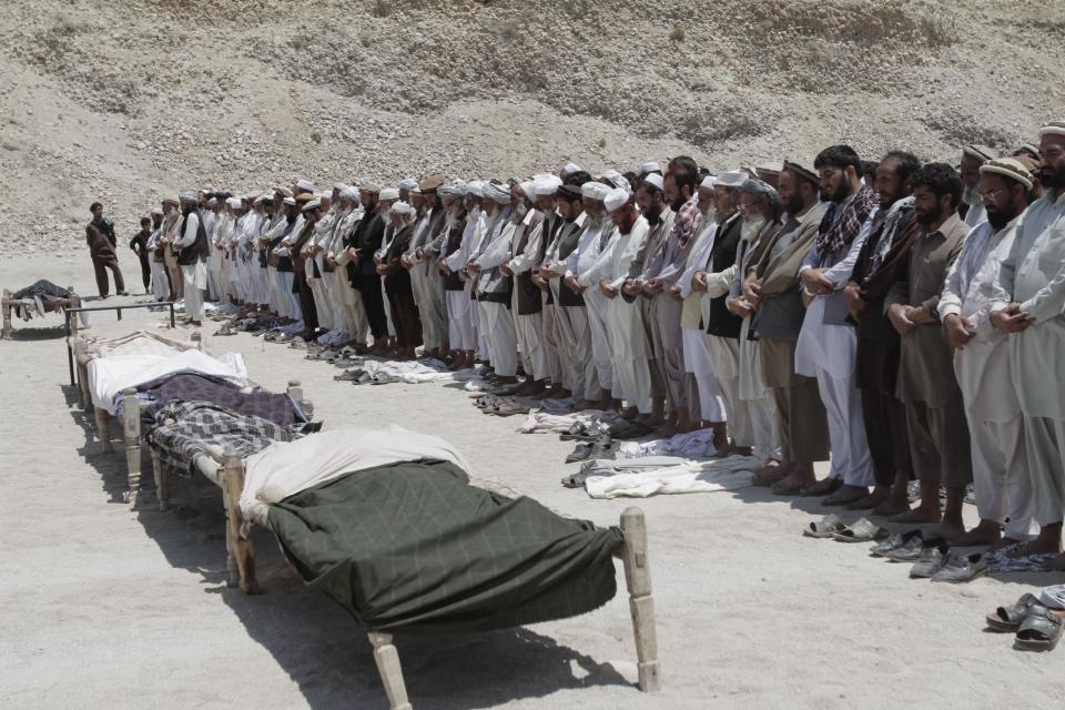 File - In this file photo taken Monday, June 3, 2013, Afghan men offer funeral prayers in front of the bodies of seven civilians killed by a roadside bomb in the Alingar district of Laghman province, east of Kabul, Afghanistan. The number of children killed and wounded in Afghanistan’s war jumped by 34 percent in 2013 as the Taliban intensified armed attacks across the country and continued to lay thousands of roadside bombs, according to a U.N. report Saturday, Feb. 8, 2014. (AP Photo/Rahmat Gul, File)