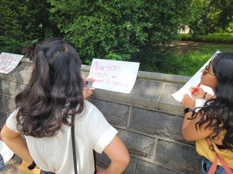 Demonstrators make picket signs on-site as the crowd grows outside the Supreme Court on Thursday (John Bowden)