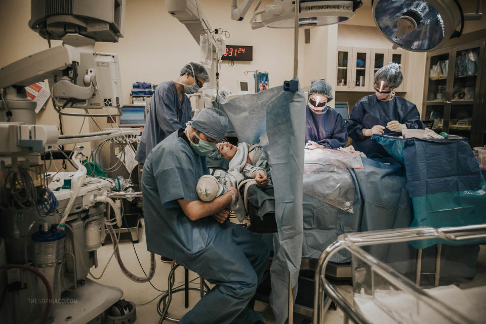 "This dad told me: 'All the action below the curtain and all the peace above it&mdash; what a wonderful moment in time. I had no idea my wife was hiring a birth photographer, but after seeing this shot, I'm so glad she did.'"