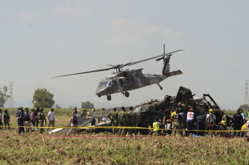 Personal de emergencia trabaja cerca de un helicóptero Blackhawk de la Marina que se estrelló luego de prestar apoyo en la captura del capo del narcotráfico Rafael Caro Quintero cerca de Los Mochis en el estado de Sinaloa, México, el 15 de julio de 2022. Las cajas negras del helicóptero serán analizadas en Estados Unidos por la empresa fabricante de la aeronave, informó el jueves 11 de agosto de 2022 el vocero de la Secretaría de Marina. (AP Foto/Guillermo Juárez)