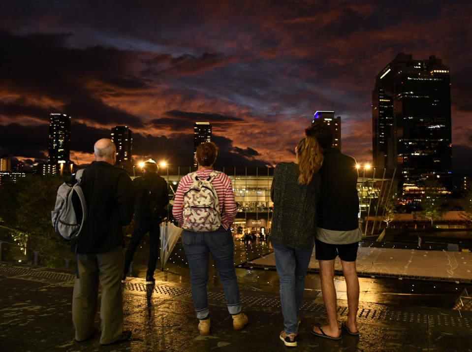 People look at clouds during sunset near Osaka Station, as typhoon 'Hagibis' approaches Japan, in Osaka, Japan Oct. 12, 2019. (Photo: Annegret Hilse/Reuters)