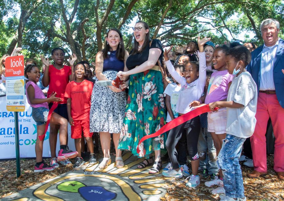 Leadership Pensacola Class of 2022 classmates Ruthie Noel, center left, and Christine Deckert cut the ribbon during the grand opening celebration for the Born Learning Trails at Highland Terrace Park in Pensacola on Tuesday.