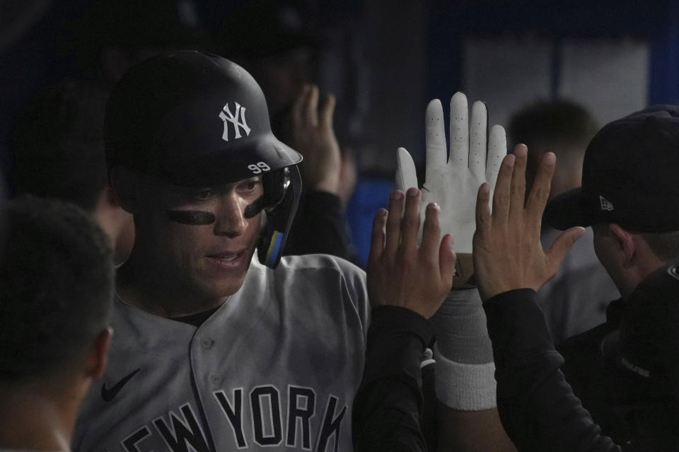 New York Yankees' Aaron Judge is congratulated for his two-run home run against the Toronto Blue Jays during the eighth inning of a baseball game Tuesday, May 16, 2023, in Toronto. (Chris Young/The Canadian Press via AP)