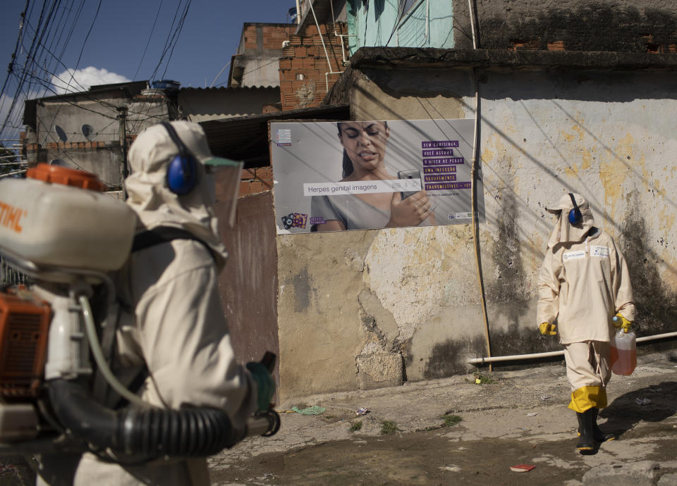 Water utility workers from CEDAE disinfect the Mare Complex slum in an effort to curb the spread of the new coronavirus, in Rio de Janeiro, Brazil, Monday, May 4, 2020. (AP Photo/Silvia Izquierdo)