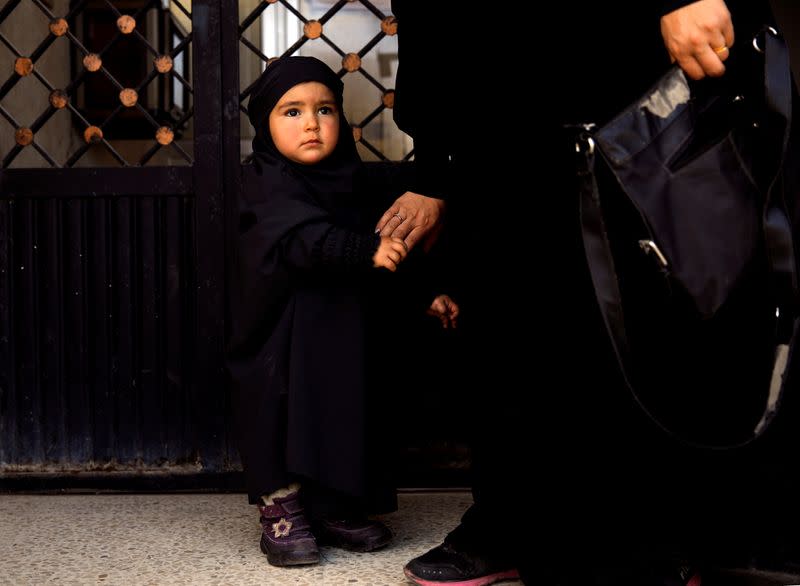 An internally displaced Syrian girl leaves a hospital with her mother in Idlib