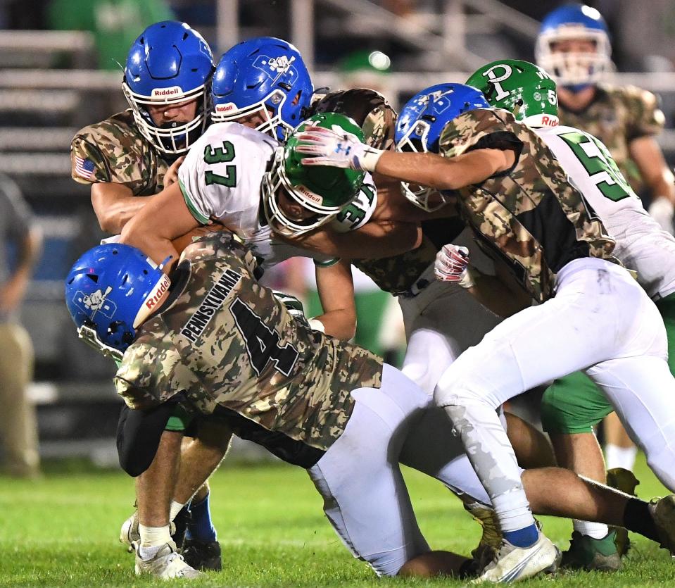 Berlin Brothersvalley defensive end Holby McClucas (4) leads the charge to bring down Portage running back Jon Wolford during a WestPAC football game, Oct. 15, in Berlin.