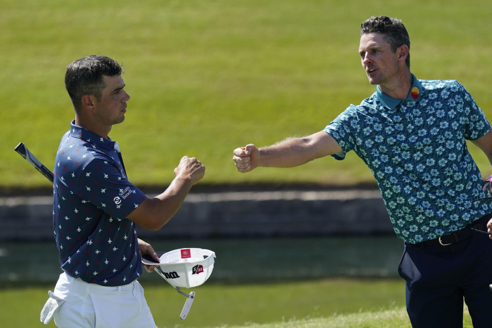 Gary Woodland, left, and Justin Rose, of England, nearly touch fists on the 18th green following the third round of the Charles Schwab Challenge golf tournament at the Colonial Country Club in Fort Worth, Texas, Saturday, June 13, 2020. (AP Photo/David J. Phillip)