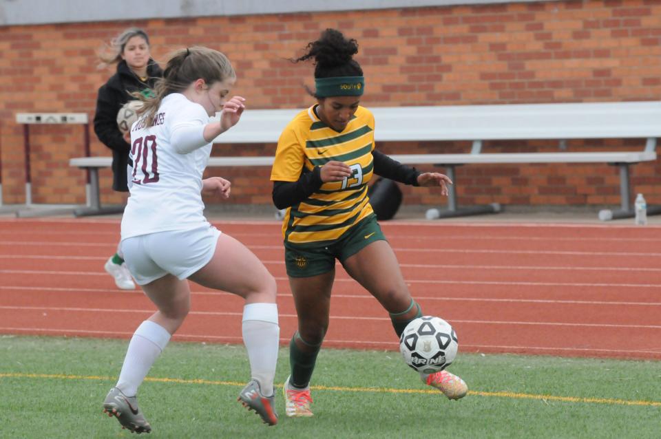 Salina South's Anahyssa Nash (13) dribbles past Salina Central's Lexie Fischer (20) during Thursday's game at Salina Stadium.