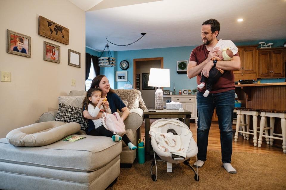 Alyssa and Brian Bostic talk while taking care of daughters Regan, 3, and Emryn, 1 month, on Wednesday in their New Philadelphia home. Emryn's birth followed two recent miscarriages. Big brother Landon, 11, (pictured on wall at left), was in school.