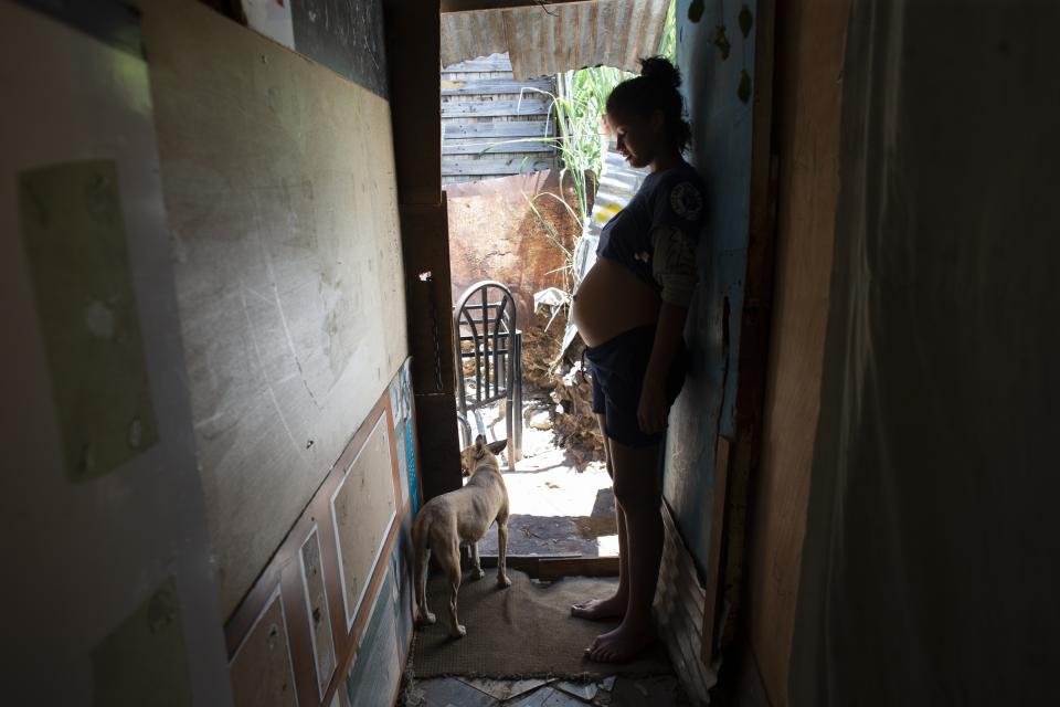 In this photo taken Aug. 5, 2019, 14-year-old Rosibeth Vargas, who is seven months pregnant, stands inside her home where she lives with her parents, 18-year-old sister and nephew, in the Tablitas area of the Caucaguita neighborhood on the outskirts of Caracas, Venezuela. Vargas said her school allows student mothers to bring their children to class, but that she dropped out after being bullied. (AP Photo/Ariana Cubillos)