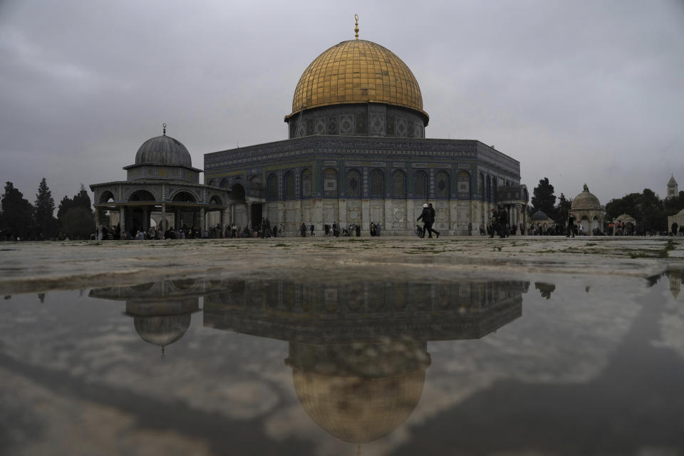 The Dome of the Rock Mosque is reflected in rainwater as worshippers gather for Friday prayers on a cold, rainy day at the Al-Aqsa Mosque compound in the Old City of Jerusalem, Friday, Jan. 6, 2023. (AP Photo/ Mahmoud Illean)