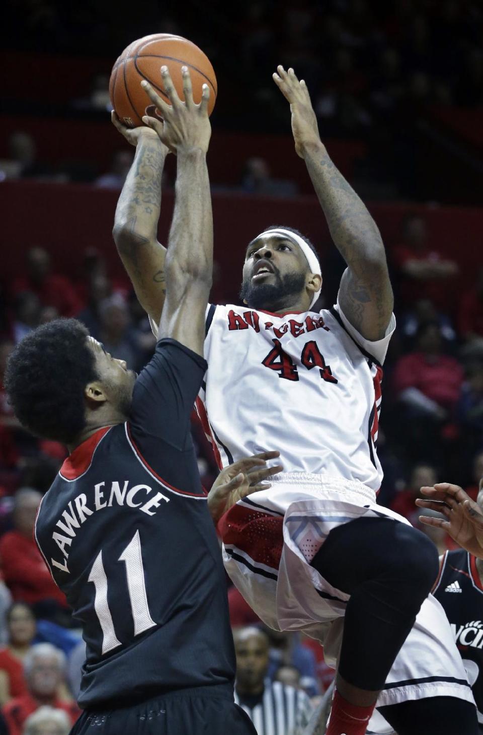 Rutgers forward J.J. Moore (44) takes a shot over Cincinnati forward Jermaine Lawrence (11) during the second half of an NCAA college basketball game Saturday, March 8, 2014, in Piscataway, N.J. Cincinnati won 70-66. Moore had 19 points for Rutgers. (AP Photo/Mel Evans)