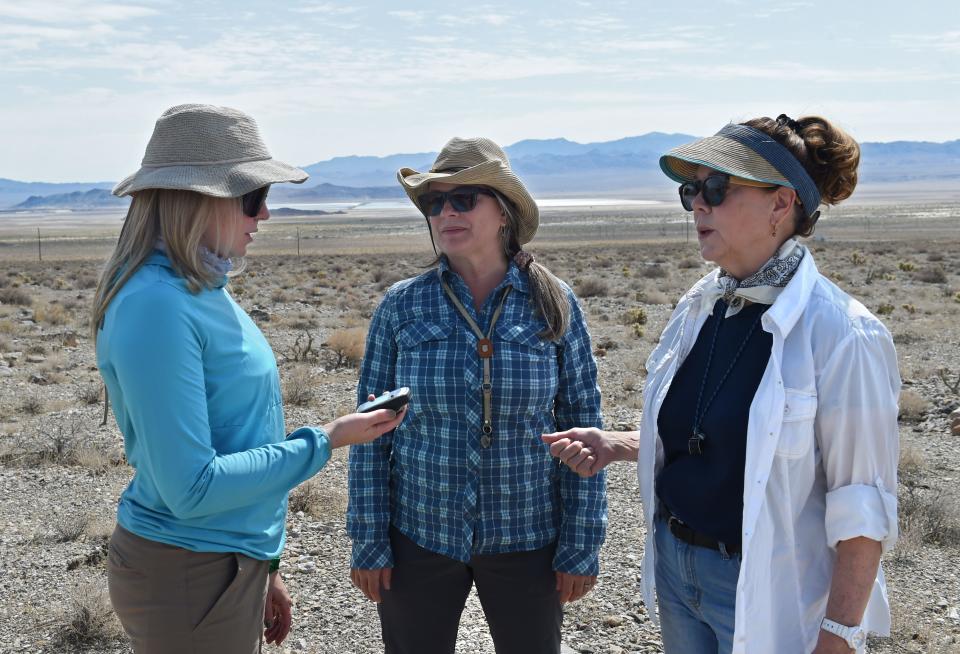 Emily Hersh, left, Lee Ann Munk, center, and Mary Little chat over a portable GPS devise while standing in the Clayton Valley in Central Nevada.