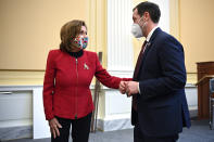 House Speaker Nancy Pelosi of Calif., and Rep. Jason Crow, D-Colo., talk after as members of Congress shared recollections of the Jan. 6, 2021, assault on the U.S. Capitol on the one year anniversary of the attack Thursday, Jan. 6, 2022. (Mandel Ngan/Pool via AP)