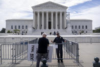 A Supreme Court police officer talks with a demonstrator at a barricade outside the Supreme Court on Thursday, June 27, 2024, in Washington. (AP Photo/Mark Schiefelbein)