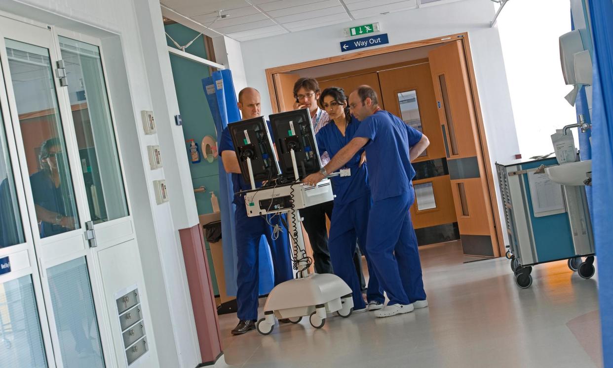 <span>Surgical staff in hospital diagnosing from scans.</span><span>Photograph: Lankowsky/Alamy</span>