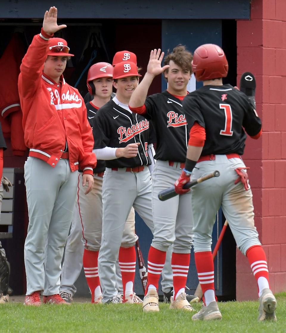 St. John’s base runner James Benestad (1) is congratulated by teammates after scoring versus Westborough on Saturday.