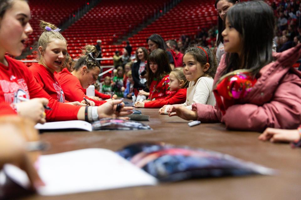 A row of little girls get posters and calendars signed by the University of Utah gymnastics team after the Red Rocks Preview at the Jon M. Huntsman Center in Salt Lake City on Friday, Dec. 15, 2023. | Megan Nielsen, Deseret News