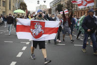 People with old Belarusian national flags march during an opposition rally to protest the official presidential election results in Minsk, Belarus, Sunday, Sept. 27, 2020.Hundreds of thousands of Belarusians have been protesting daily since the Aug. 9 presidential election. (AP Photo/TUT.by)