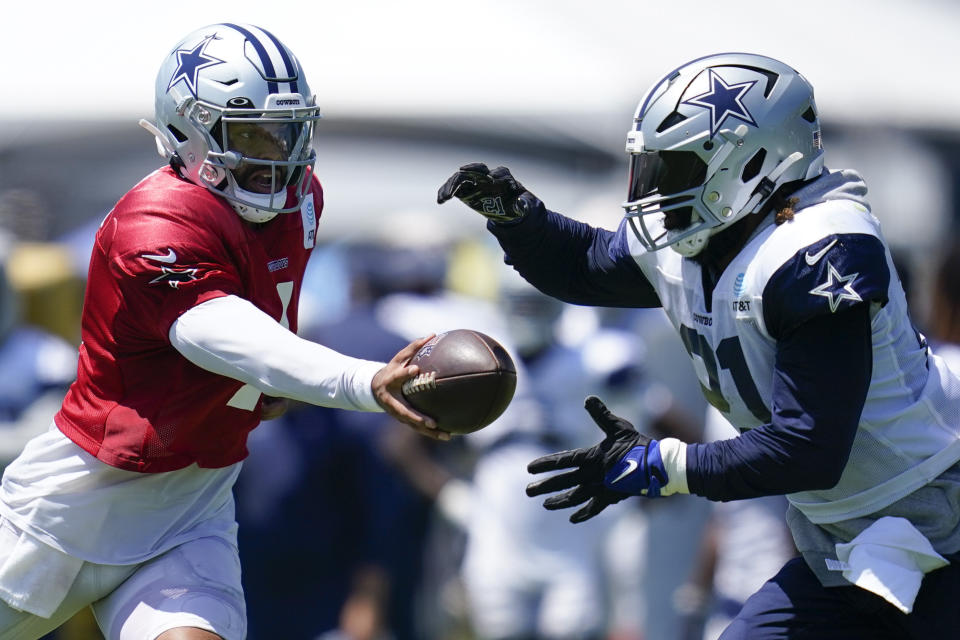 Dallas Cowboys quarterback Dak Prescott (4) and running back Ezekiel Elliott (21) participate in drills during a combined NFL practice at the Los Angeles Rams' practice facility in Costa Mesa, Calif. Wednesday, Aug. 17, 2022. (AP Photo/Ashley Landis)