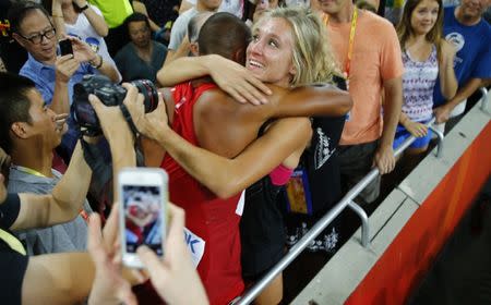 Ashton Eaton of the U.S. hugs his wife Brianne Theisen-Eaton after his 1500 metres heat to win the men's decathlon at the 15th IAAF Championships at the National Stadium in Beijing, China August 29, 2015. REUTERS/Damir Sagolj