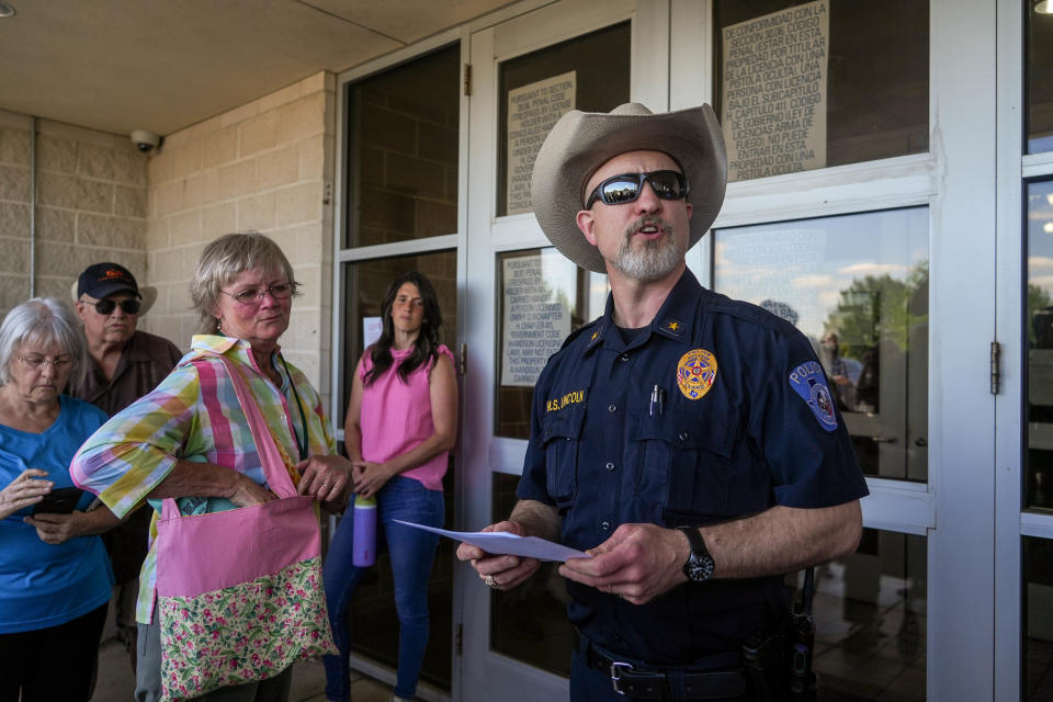 Llano Assistant Police Chief Matt Lincoln calls the names of community members to testify at Thursday's Llano County Commissioners Court meeting. So many people showed up for the meeting that officers cited a lack of space in the hearing room.